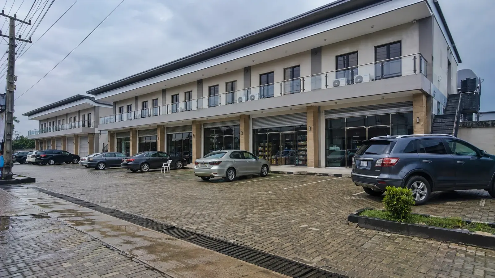Completed two-storey commercial development with paved parking and glazed shopfronts