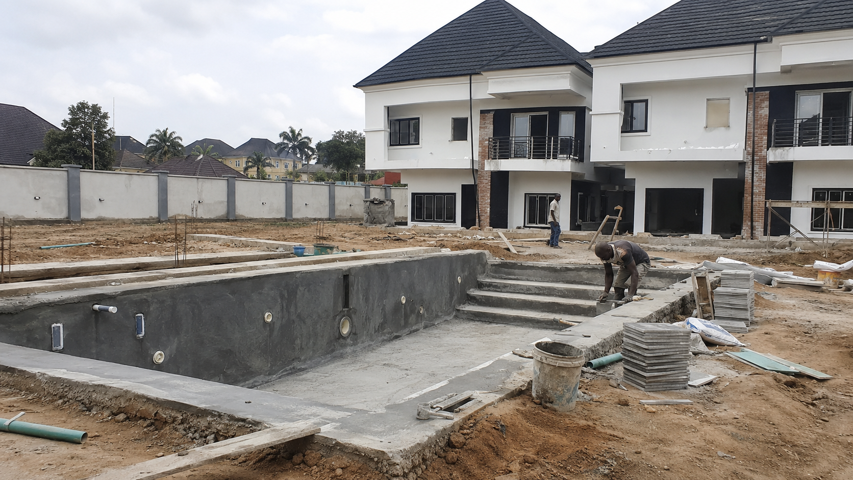 Swimming pool shell at finishing stage with coping, steps and stacked tiles